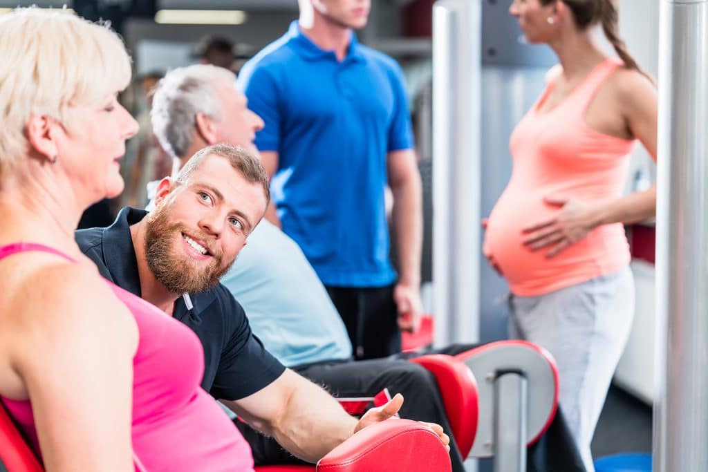Senior woman in group with pregnant woman working out at the gym
